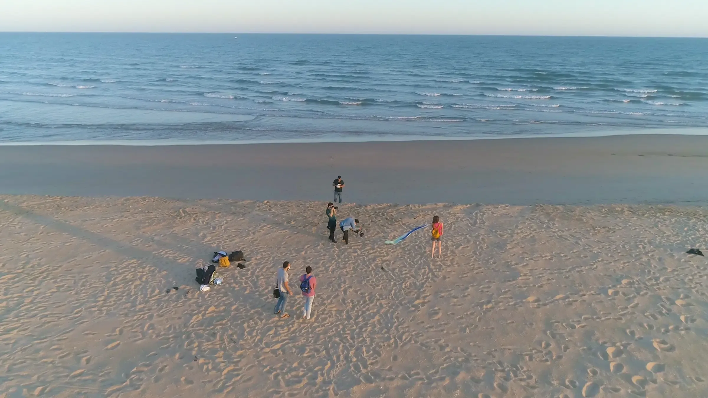 Vista aérea de un rodaje del equipo de Bis en la playa, con el material preparado junto a la orilla