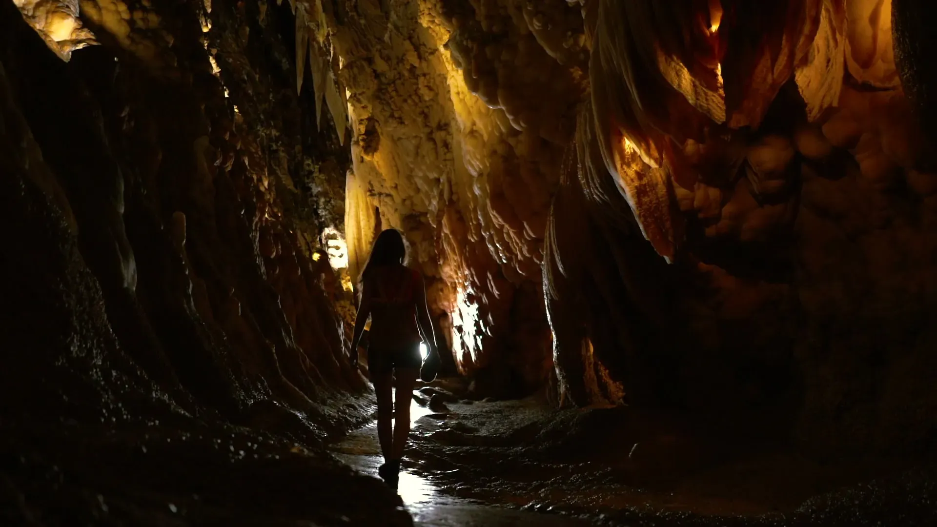 Una persona camina por el interior de una gruta iluminada, en un destino natural de Huelva